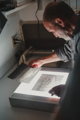 a man is looking at a picture on a table