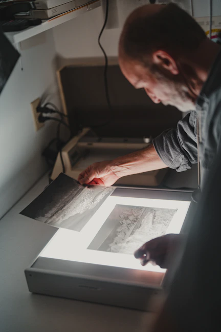 a man is looking at a picture on a table