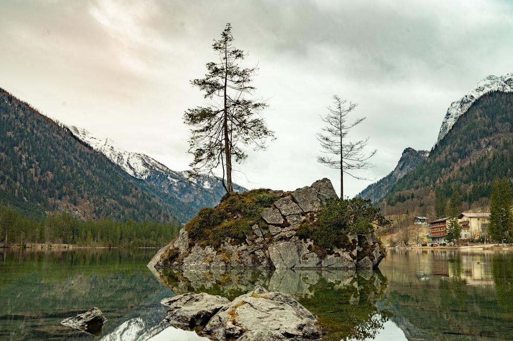 a small island in the middle of a lake surrounded by mountains