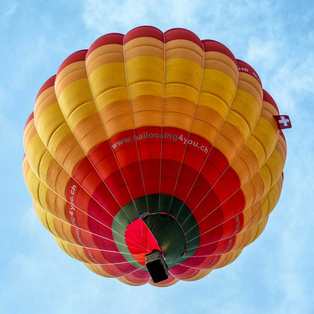 a large colorful hot air balloon flying through a blue sky