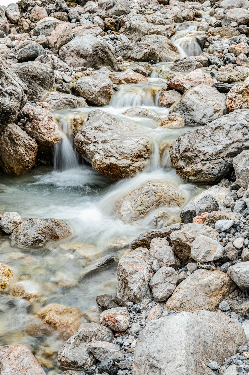 a small stream of water running between rocks