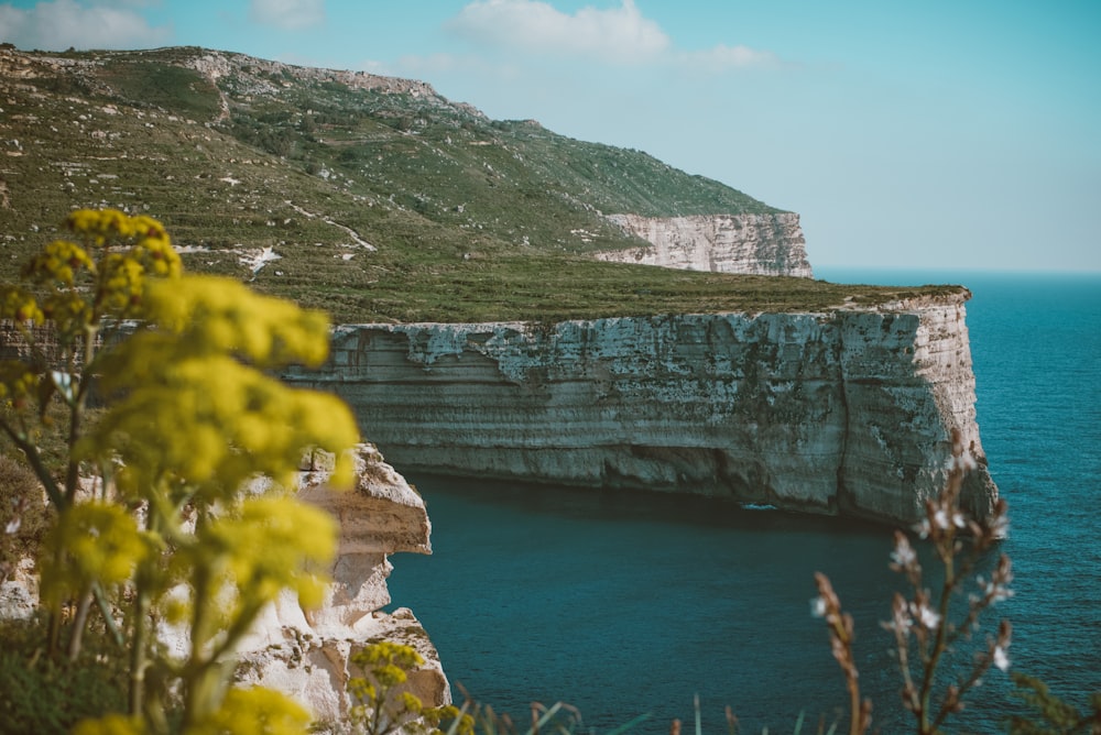 a view of a cliff with a body of water in the foreground