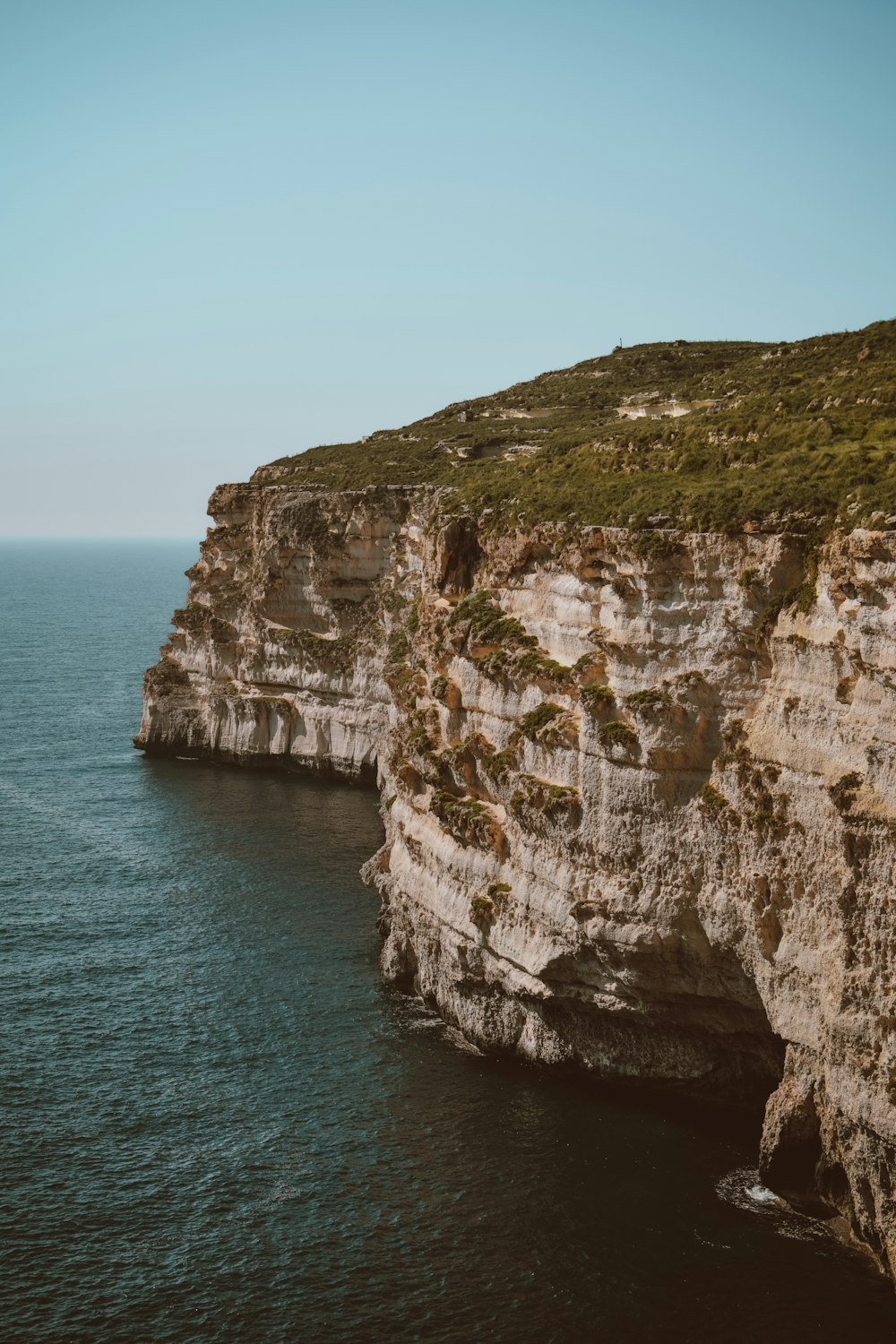 a large body of water next to a rocky cliff