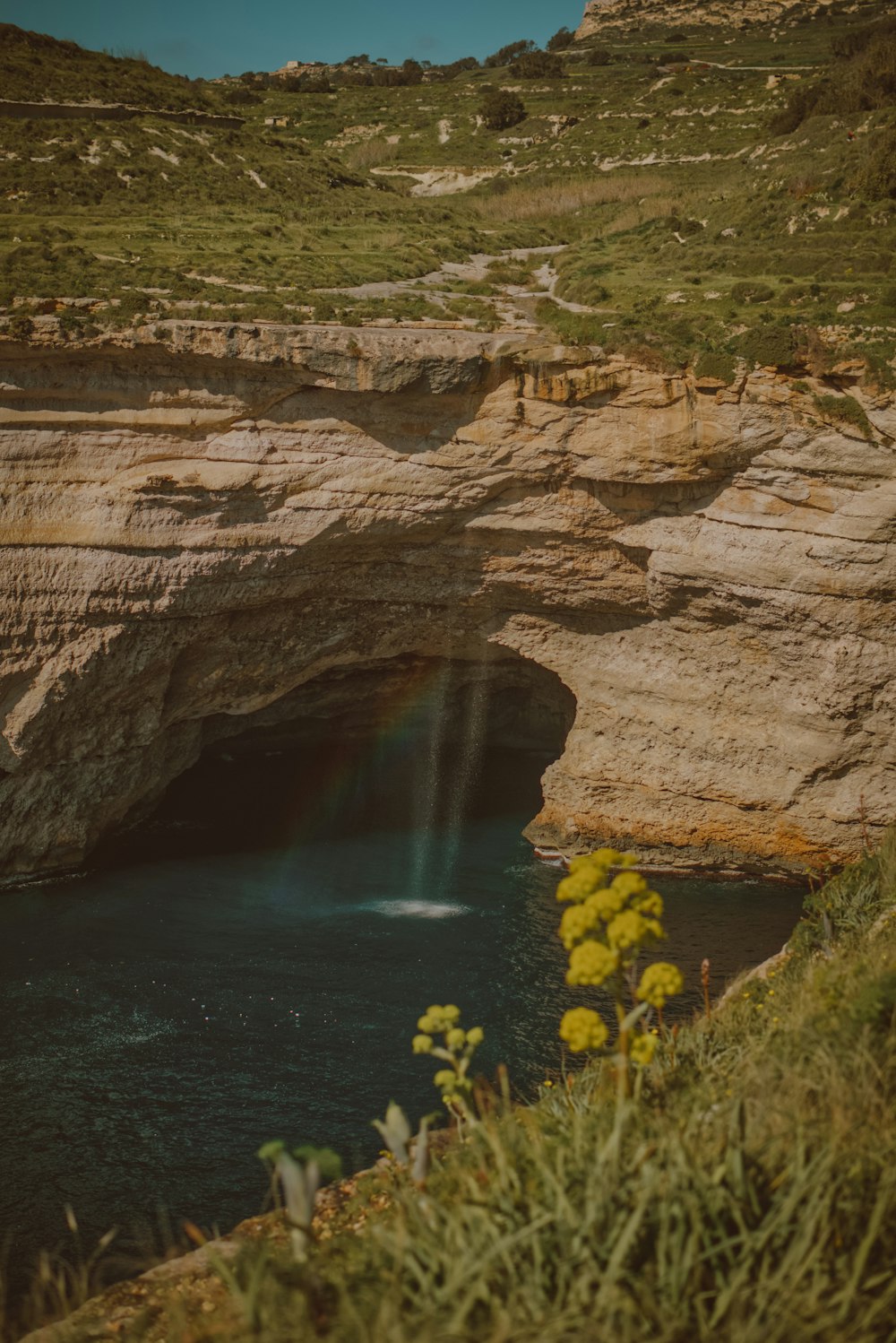 a small waterfall in the middle of a large body of water