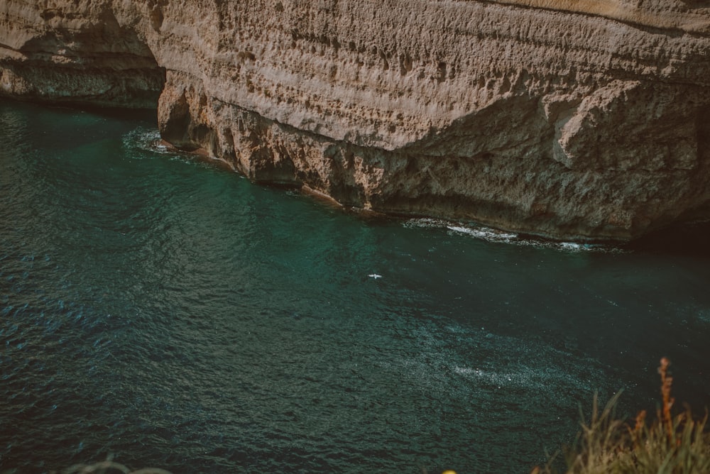 a body of water next to a cliff