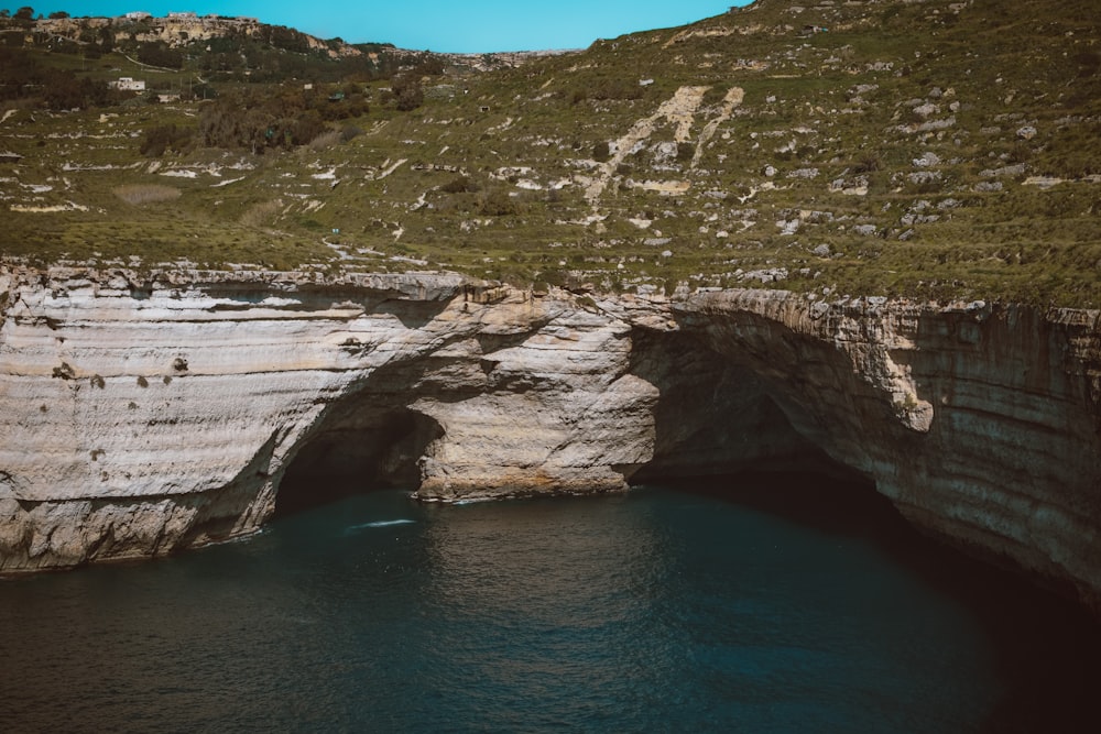 a large body of water near a rocky cliff