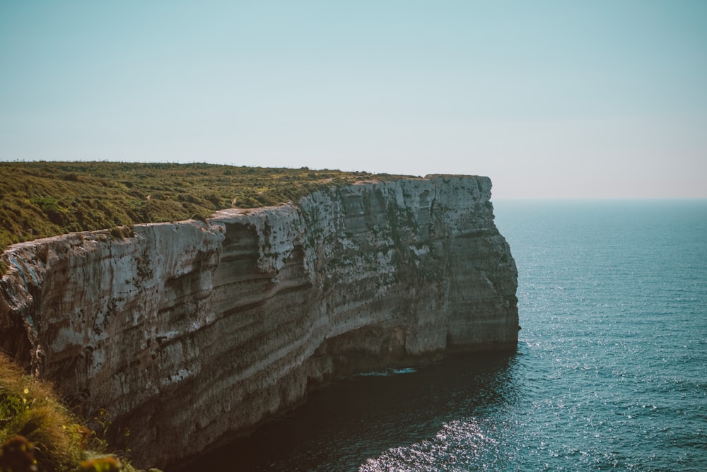 a large cliff with a boat in the water