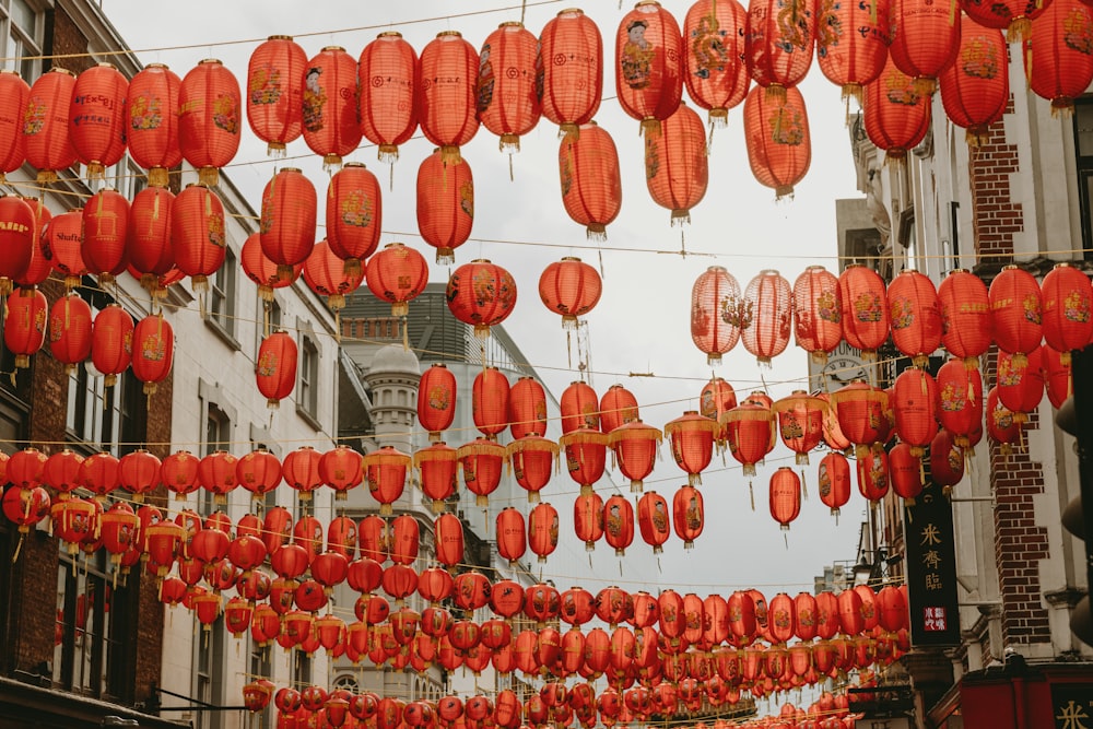 a bunch of red paper lanterns hanging from a line