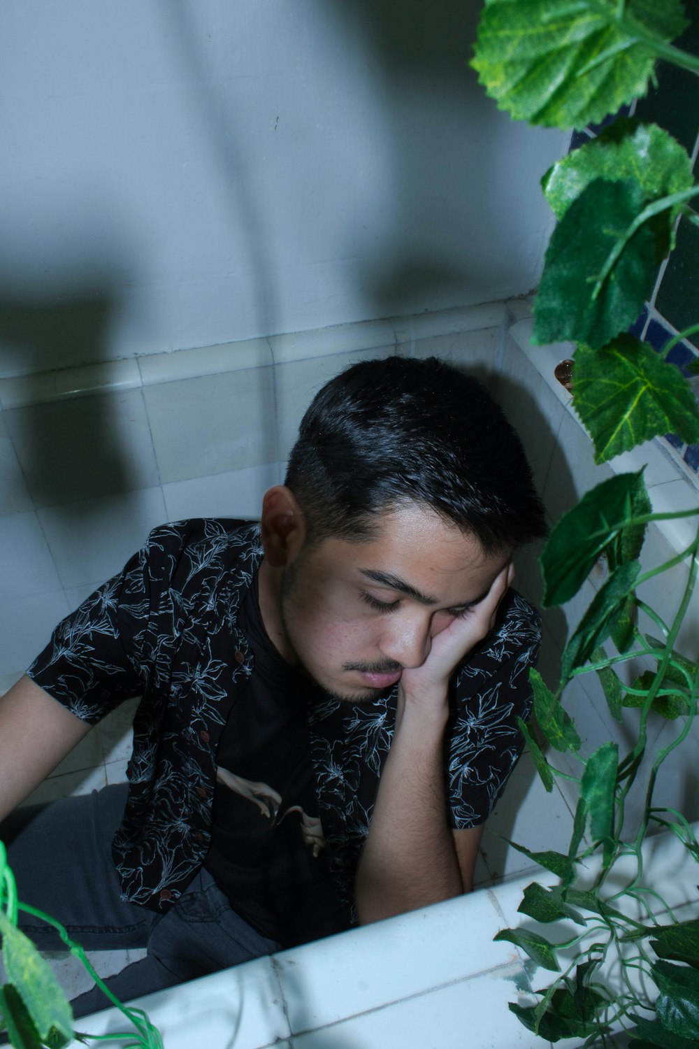 a man sitting in a bathtub with his head in his hands