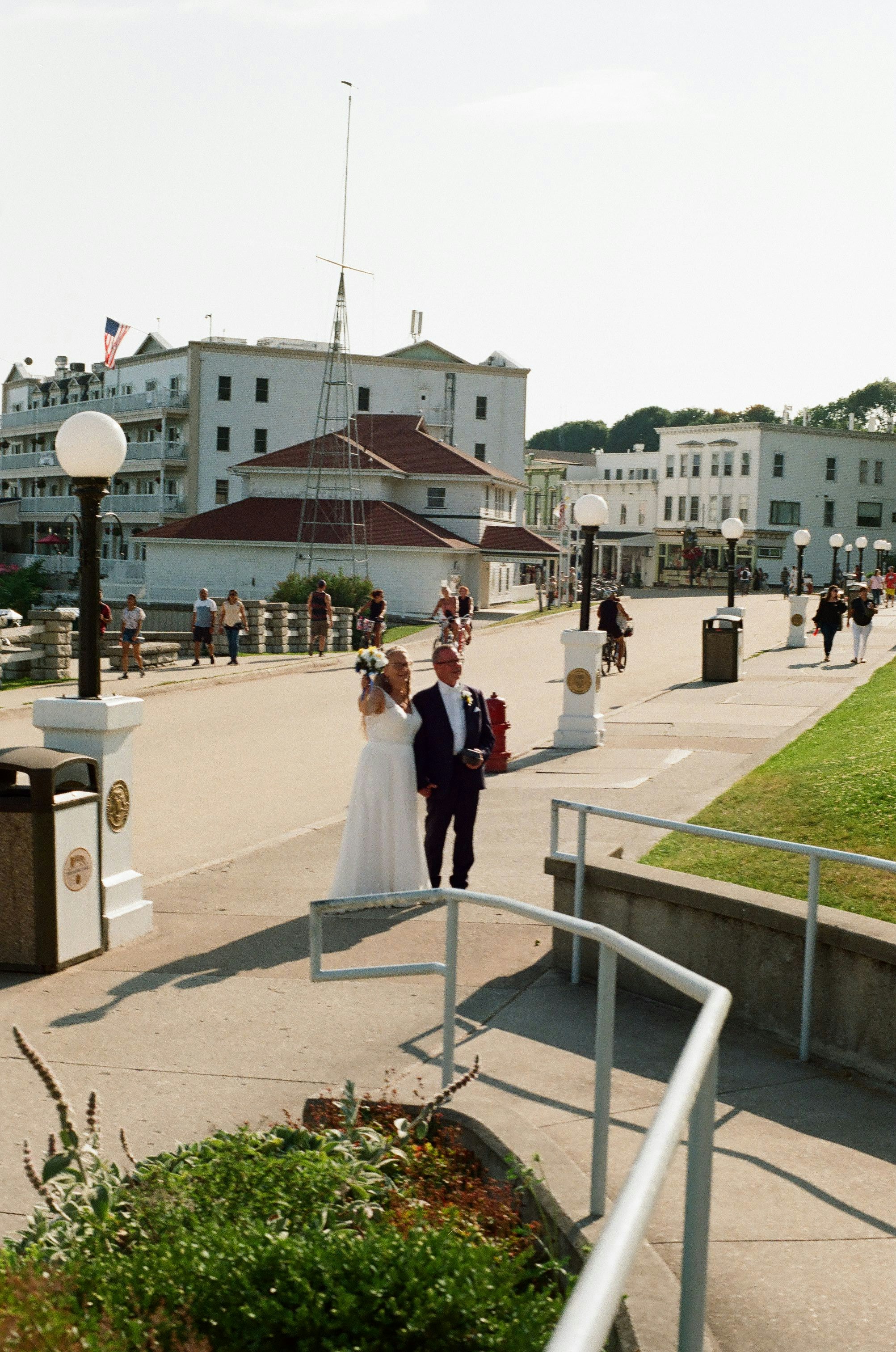 a bride and groom walking down the street