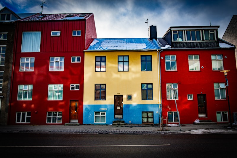 Row of red, yellow, and blue corrugated-iron houses along a Reykjavík street under a moody sky