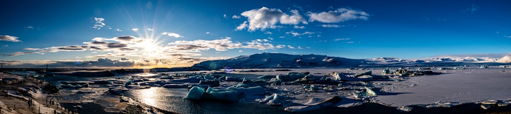 the sun shines brightly over a frozen lake