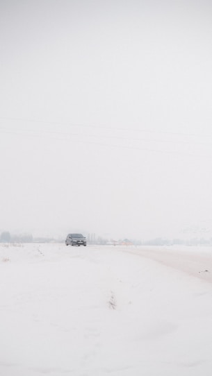 a car driving down a snow covered road