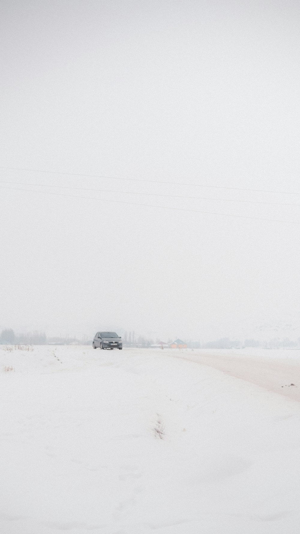 a car driving down a snow covered road