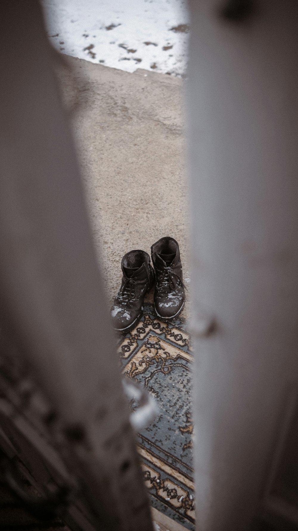 a pair of black shoes sitting on top of a rug