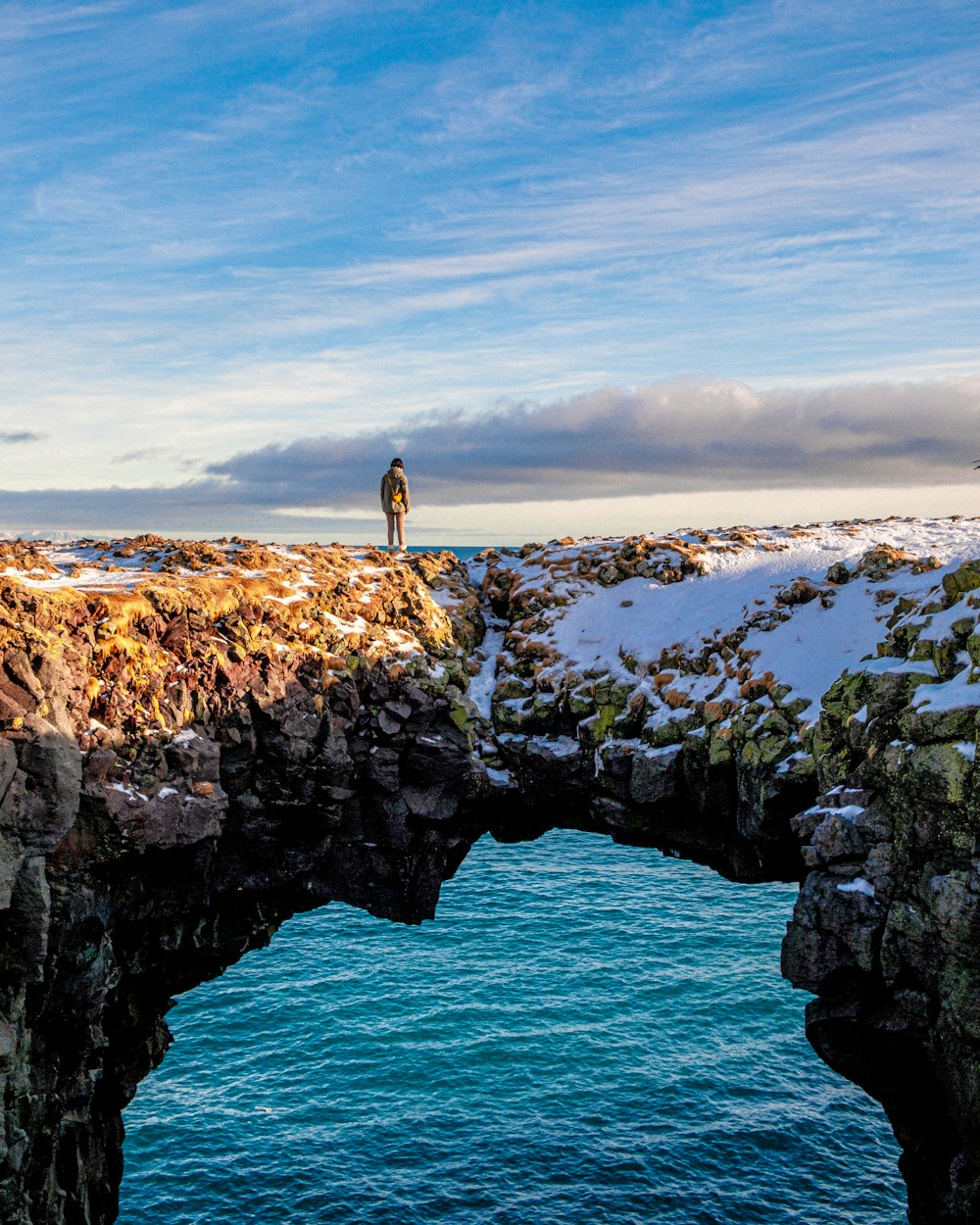 a person standing on a bridge over a body of water