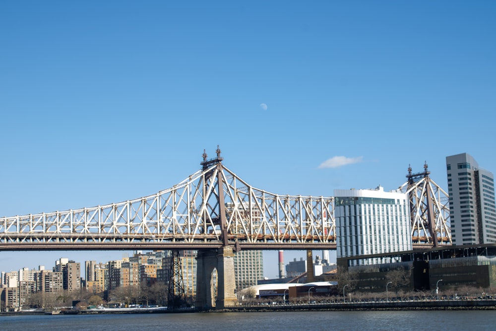 a bridge over a body of water with a city in the background