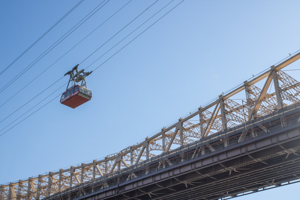 a cable car going over a bridge on a sunny day