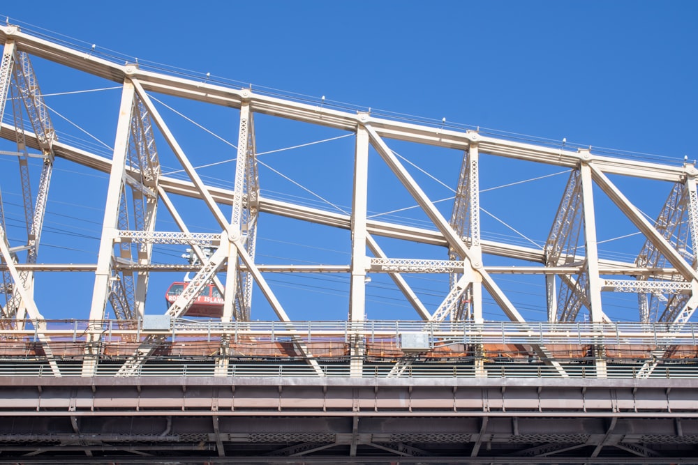 a train traveling over a bridge under a blue sky