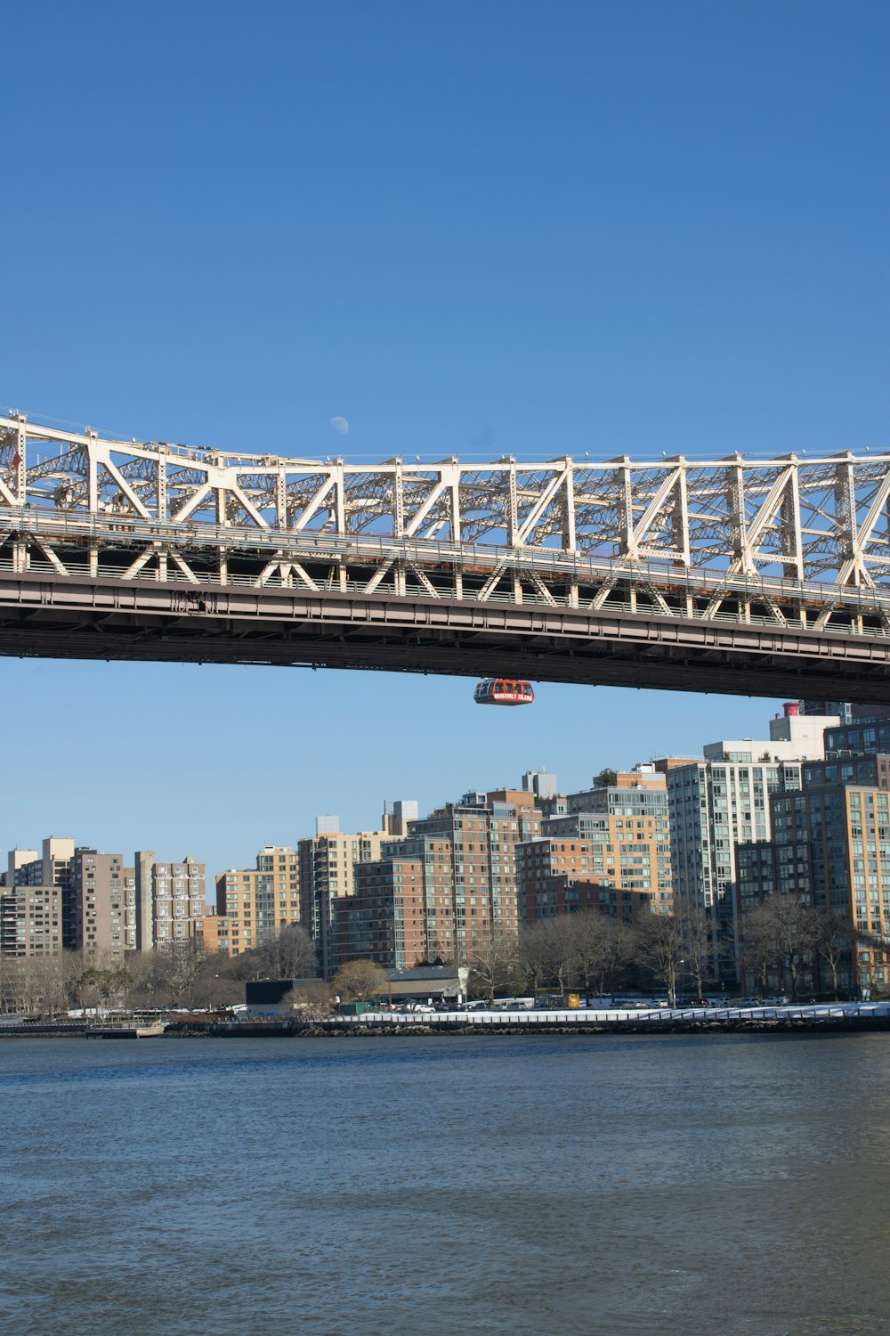 a bridge over a body of water with buildings in the background