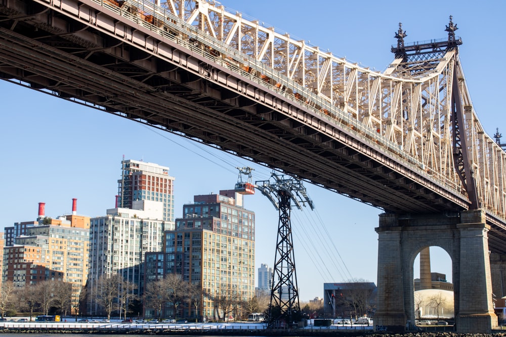 a bridge over a body of water with buildings in the background