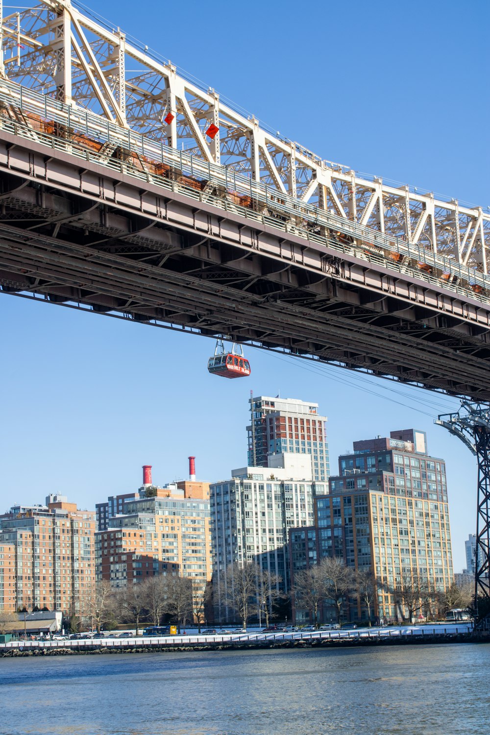 a bridge over a body of water with a city in the background