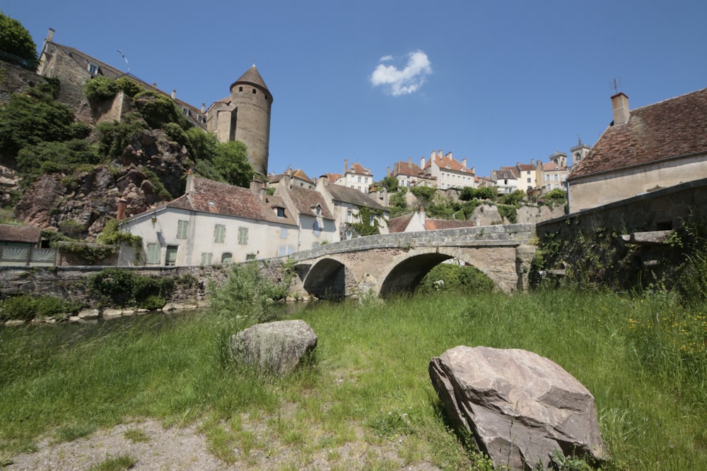 Un puente de piedra sobre un río junto a una exuberante ladera verde