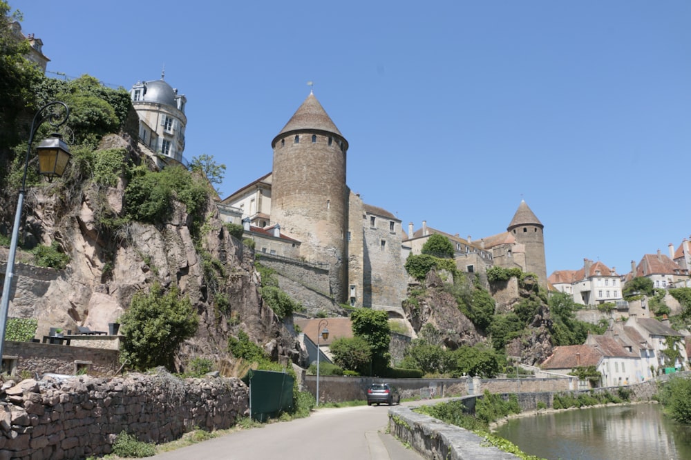 a castle on top of a hill next to a river