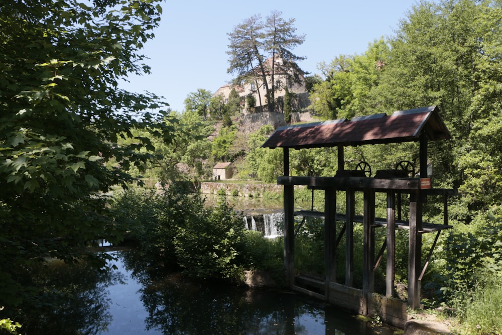 a small wooden bridge over a river surrounded by trees