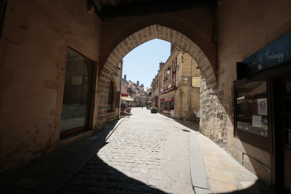 a narrow street with a stone arch in the middle