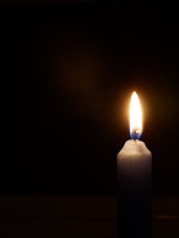 a lit candle with a dark background