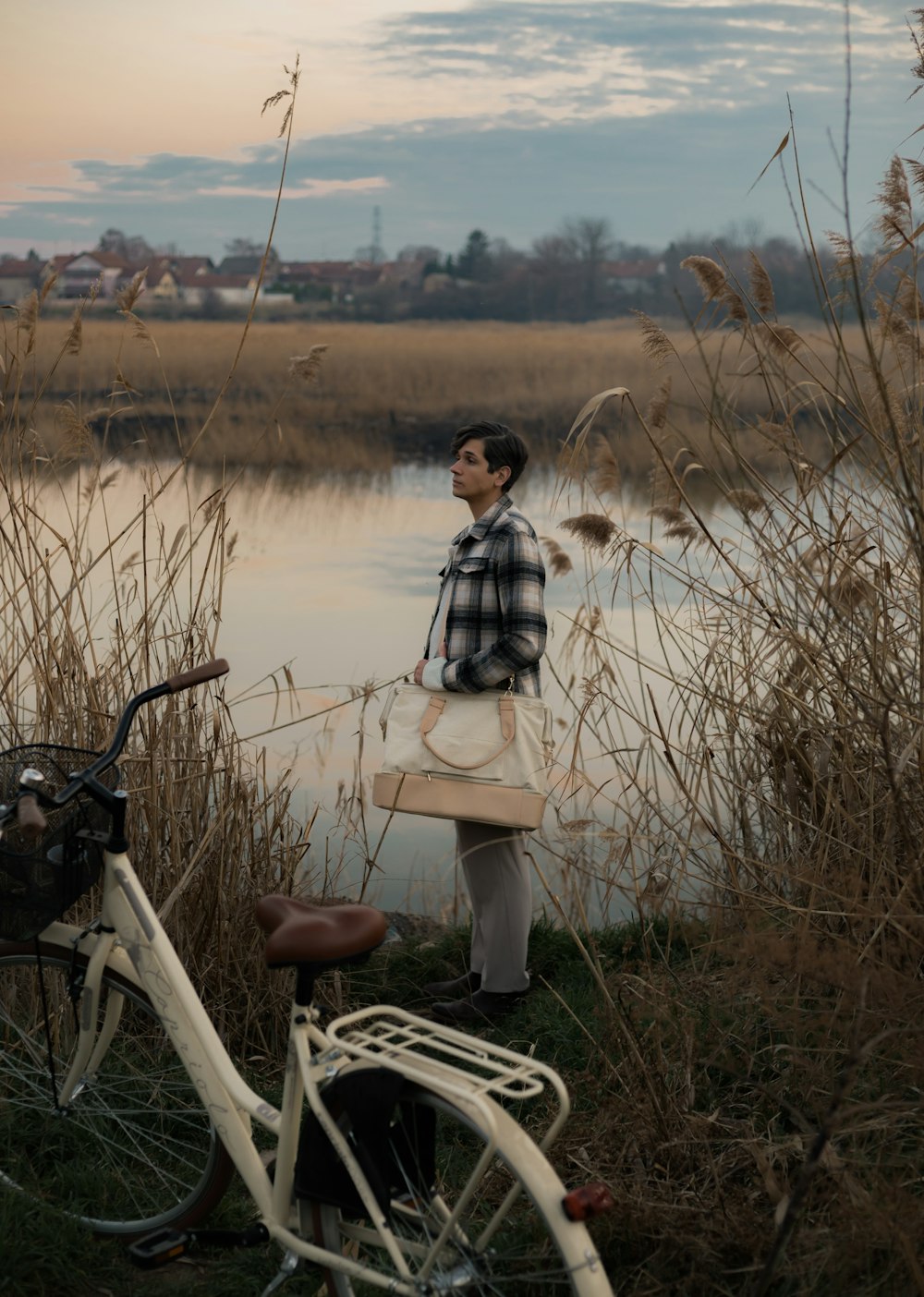 a man standing next to a bike near a body of water