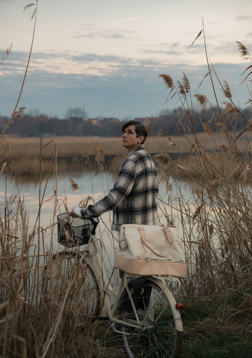 a man standing next to a bike near a body of water