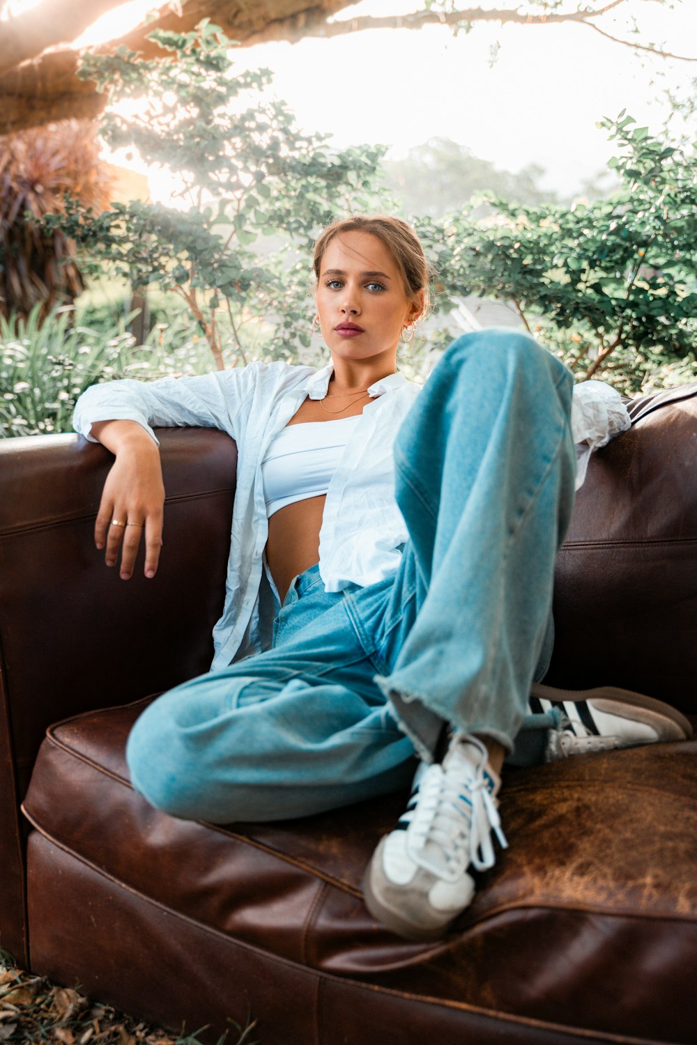 a woman sitting on top of a brown couch