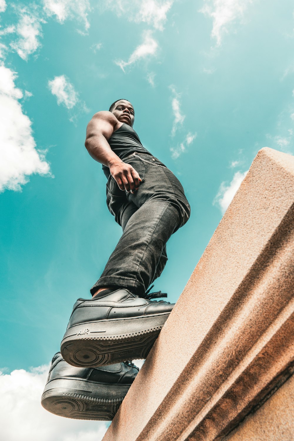 a man standing on top of a cement pillar