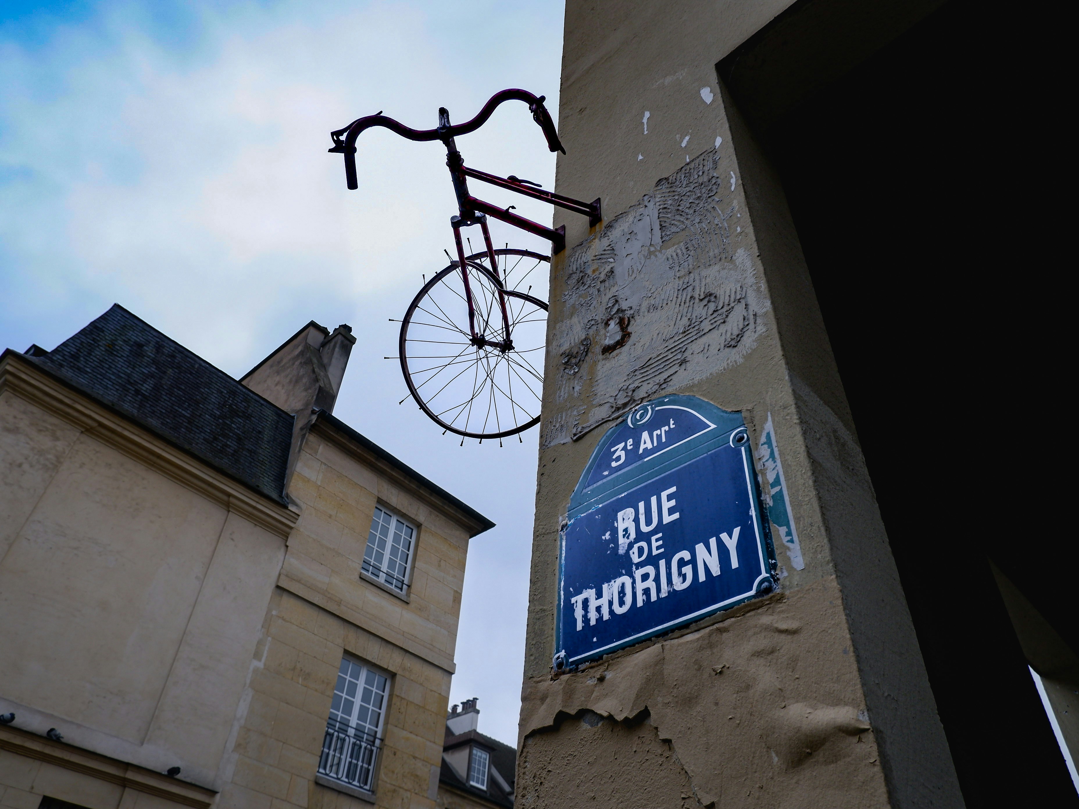 a bicycle hanging from the side of a building, A bike in the sky