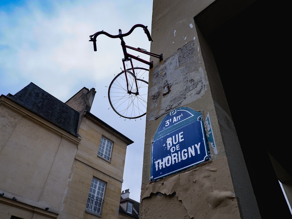 a bicycle hanging from the side of a building