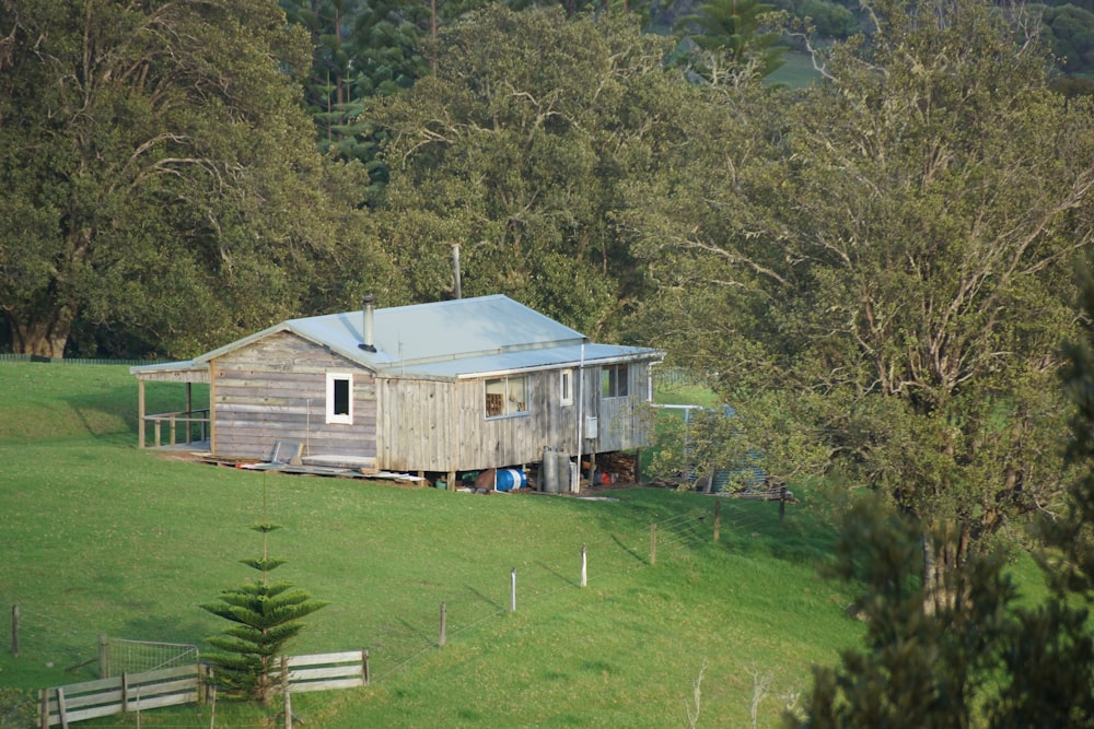 a small wooden cabin sitting on top of a lush green hillside