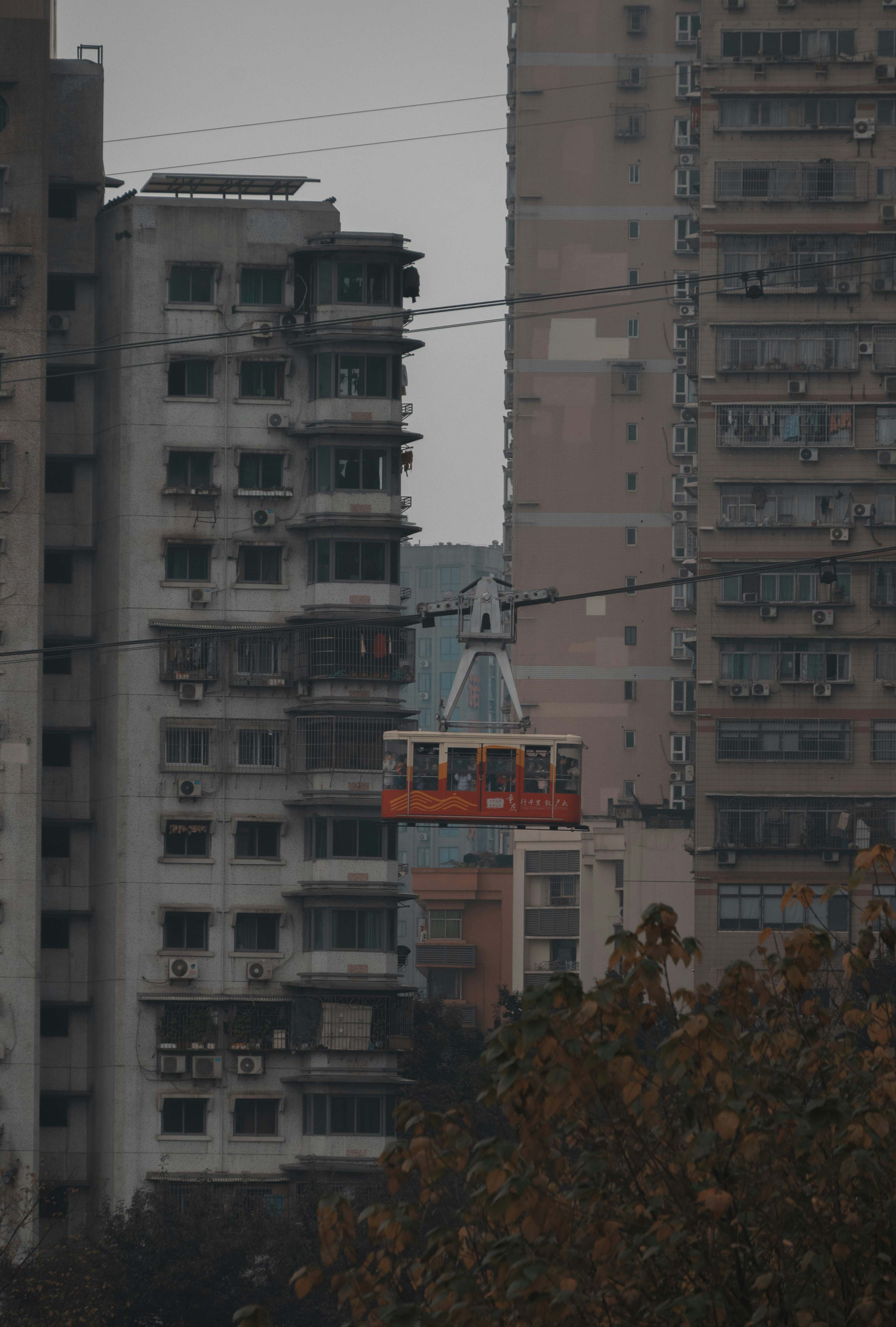 Un teleférico atravesando una ciudad con edificios altos al fondo