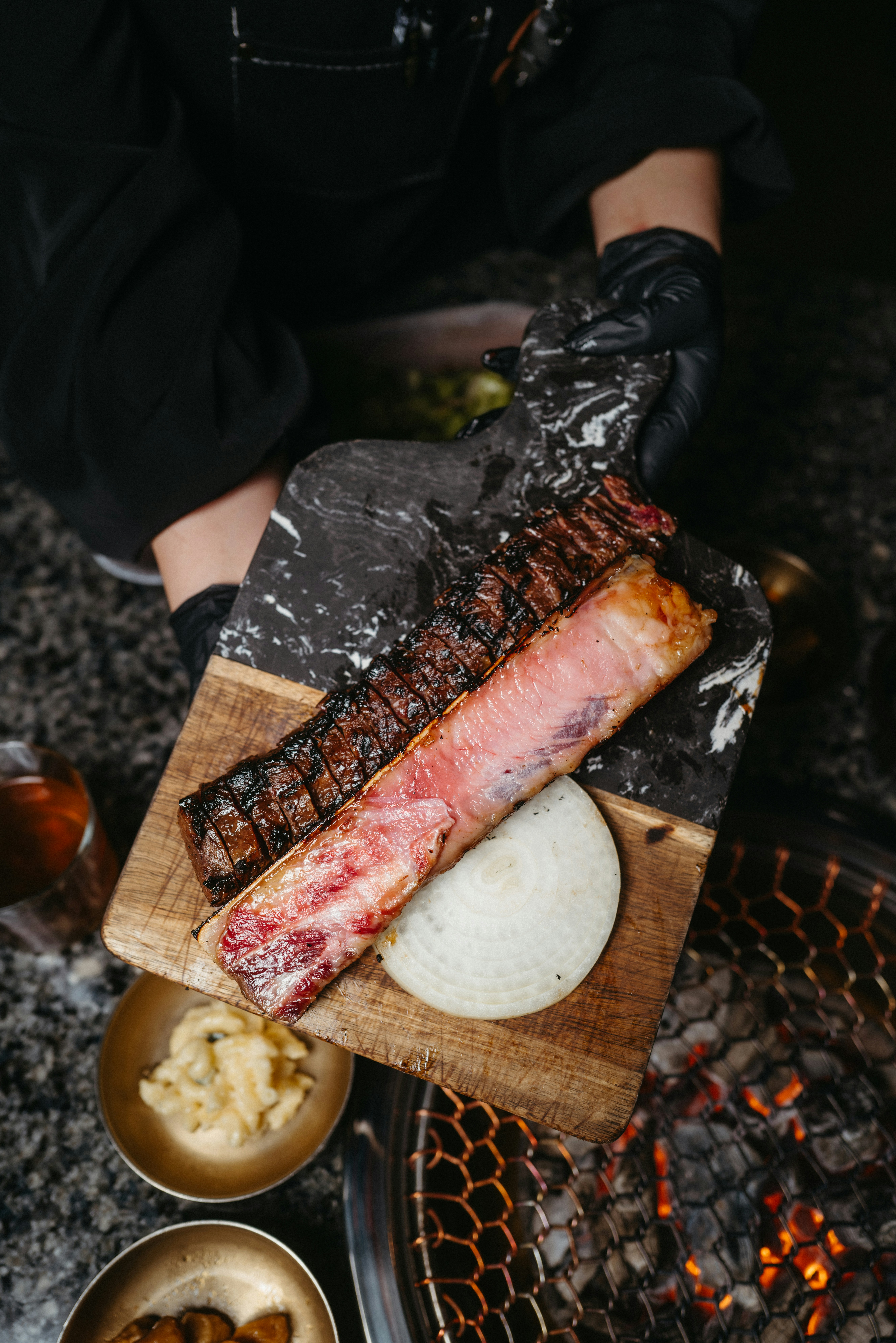 a person holding a piece of meat on a cutting board