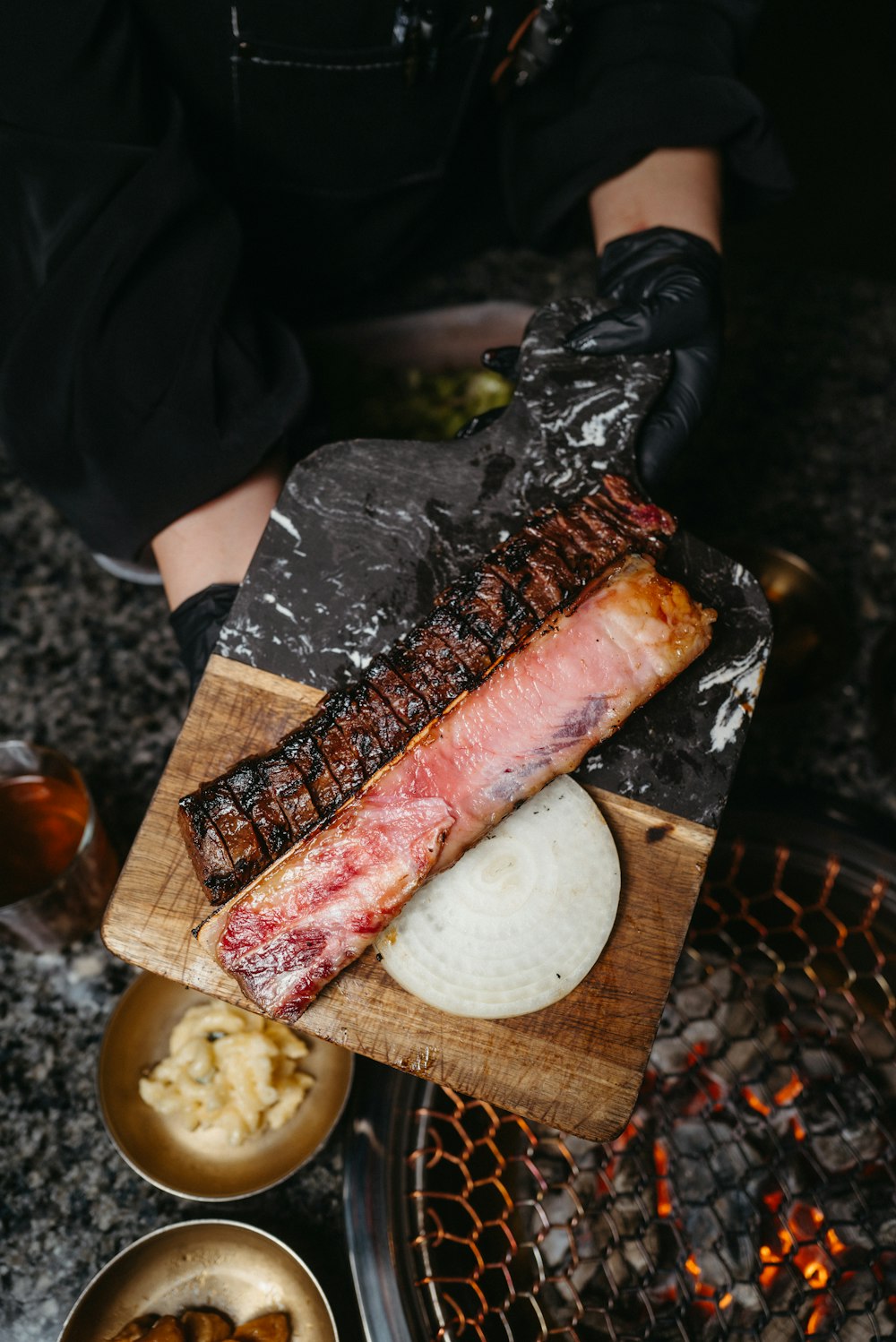 a person holding a piece of meat on a cutting board