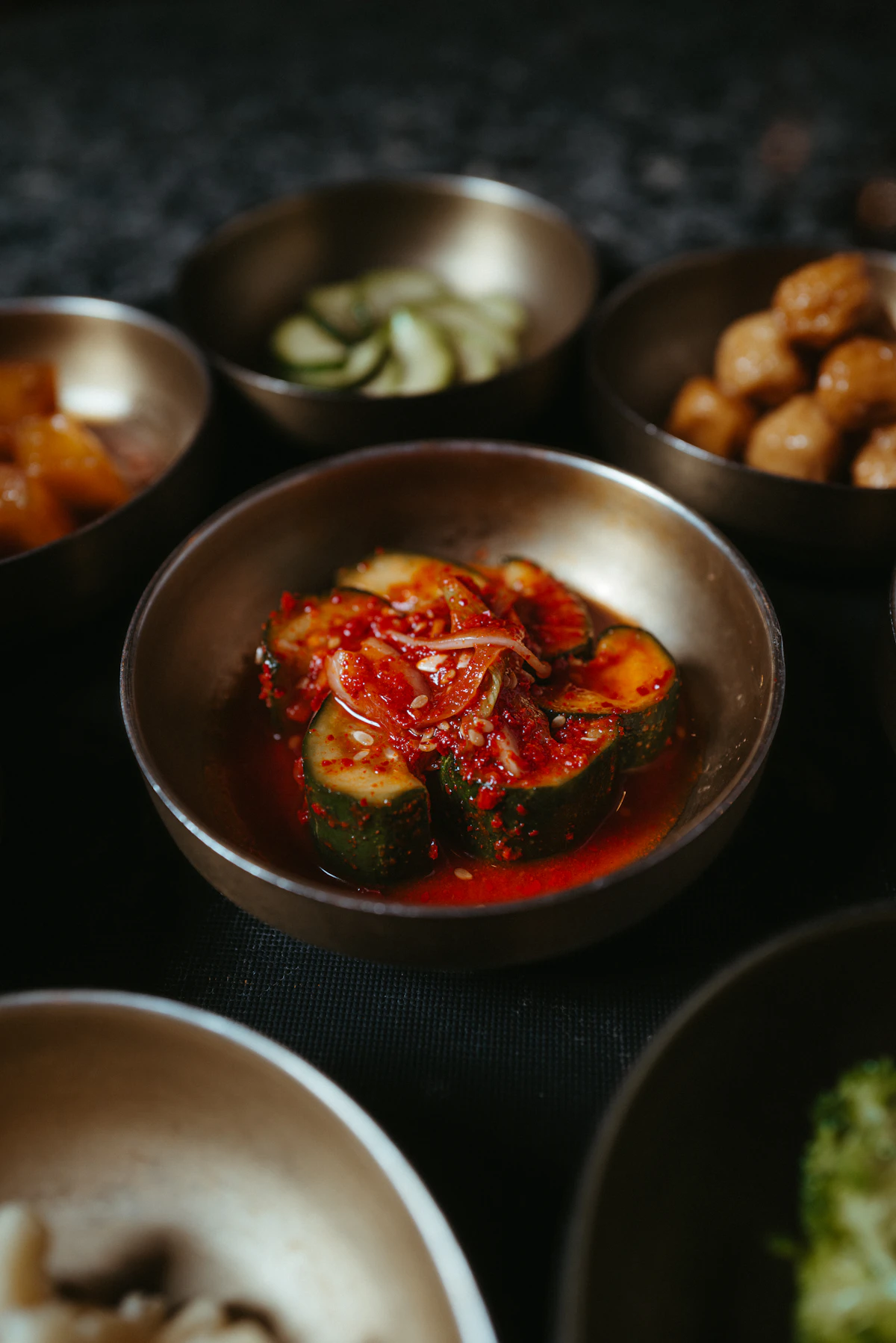 Banchan Hàn Quốc được bày trong các bát kim loại nhỏ trên bàn ăn