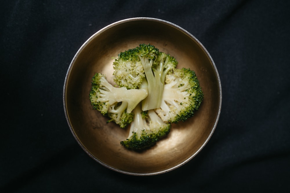 a metal bowl filled with broccoli florets