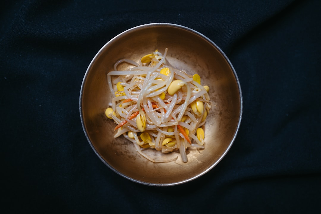 a metal bowl filled with food on top of a black table, Immerse yourself in the rich culture of Korean cuisine with a del