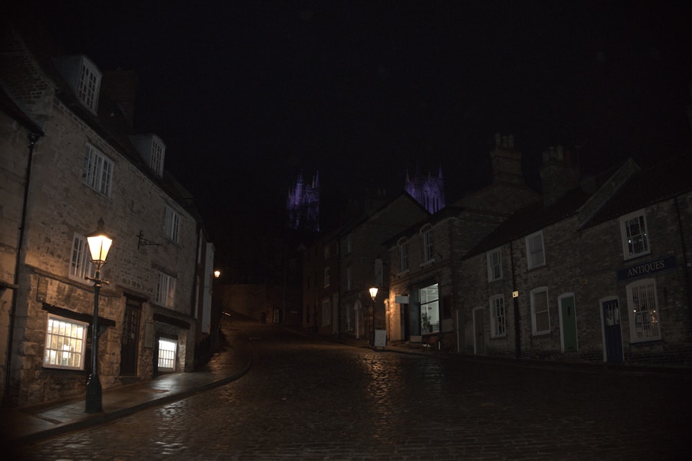 a cobblestone street at night with a light on