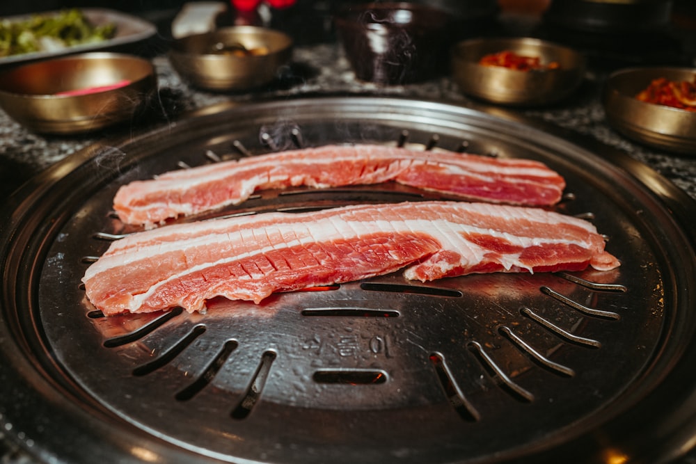 two pieces of meat sitting on top of a frying pan