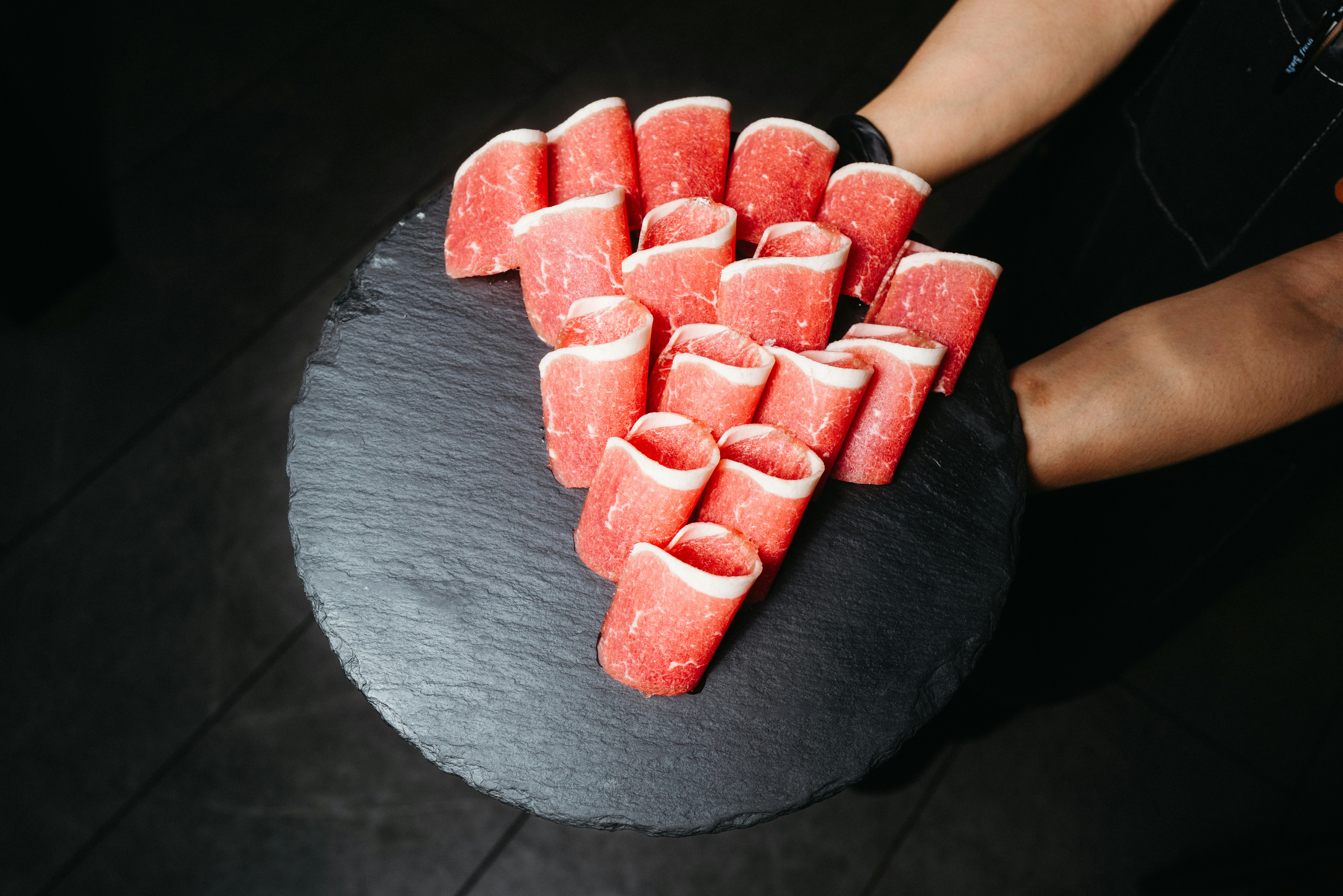 a black plate topped with slices of watermelon, 