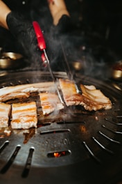 a person is cooking food on a grill