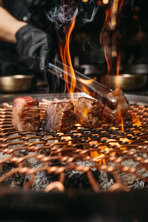 Skewers of Korean grilled marinated meat over an open flame
