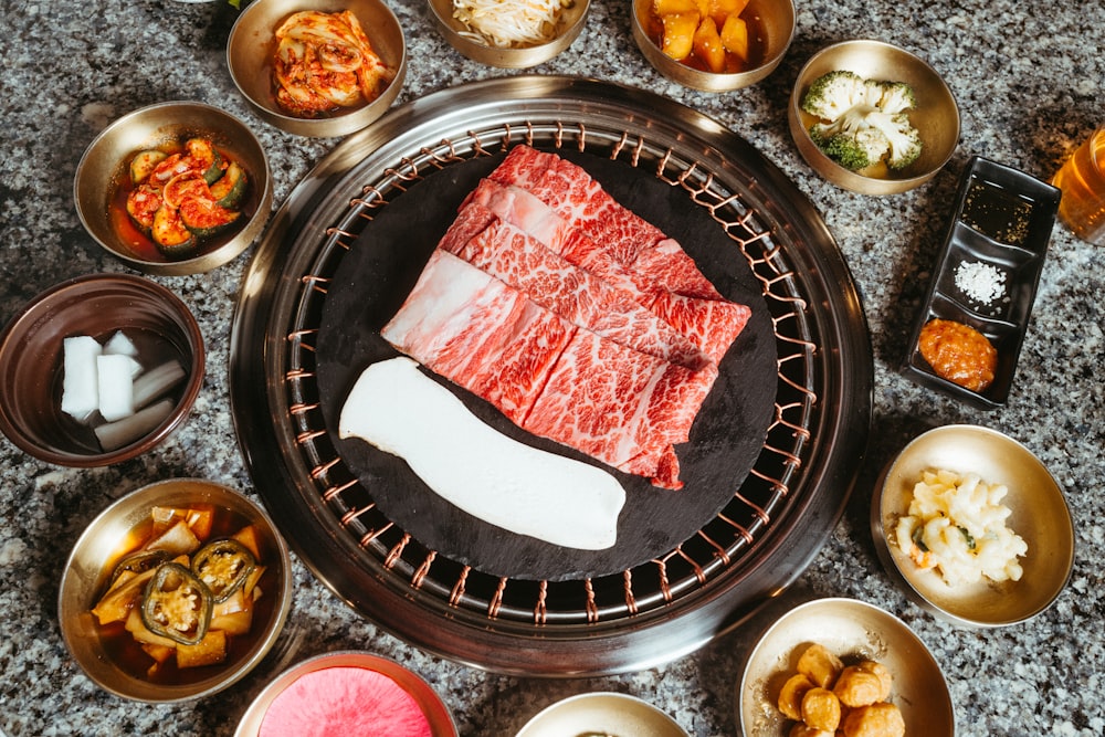 a table topped with bowls of food and meat